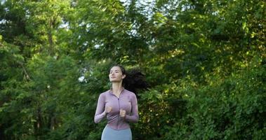 Woman warm up in the garden outdoors for a workout. Asian female practicing yoga in the park. Healthy, exercise, fitness and lifestyle concept.