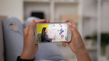 dichtbij omhoog mobiel van vrouw aan het kijken smartphone Bij huis. Aziatisch vrouw streaming leven uitzending video Aan scherm mobiel met een veel van emoji Leuk vinden en emotie liefde.