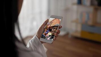 Close up mobile of woman watching smartphone at home. American man travel blogger streaming live broadcast video on screen mobile with a lot of emoji like and emotion love.