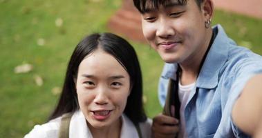 Closeup of Happy young asian blogger couple waving hand via camera and looking at camera in ancient temple. Smiling male and female selfie. Holiday, vacation and Travel concept. video