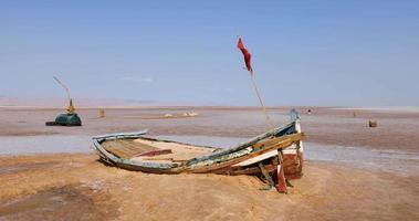 salt sjö i tunisien chott el djerid under en solig blåsigt dag. största salt sjö i de sahara öken. turist destination. resa de värld. båt på de torr sjö. mystisk landskap. video