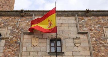 bandera española moviéndose con el viento en la ciudad vieja de cáceres. video