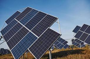 campo con baterías solares en el día soleado. concepción de la ecología y el combustible foto