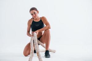 Sits with knot. Young woman with slim body type isolated against white background photo