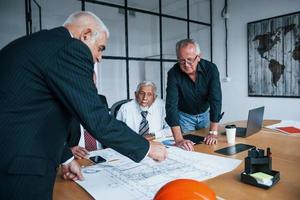 Aged team of elderly businessman architects have a meeting in the office photo