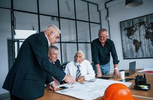 Aged team of elderly businessman architects have a meeting in the office photo