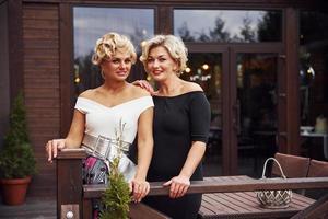 Women in formal clothes stands together near building at daytime photo