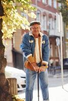 Stylish senior in fashionable clothes and in glasses have a walk in the city photo