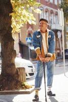 Stylish senior in fashionable clothes and in glasses have a walk in the city photo