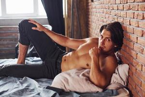 Shirtless sexy man have a rest alone in his bedroom at morning time photo