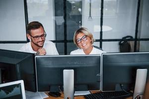 Two stockbrokers in formal clothes works in the office with financial market photo