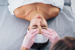 Close up view of woman that lying down in spa salon and have face cleaning procedure photo