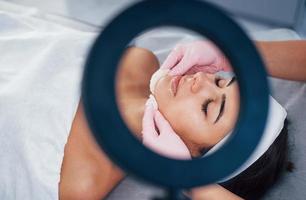Close up view of woman that lying down in spa salon and have face cleaning procedure photo