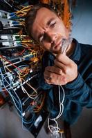 Close up view of funny man with internet wires in server room photo