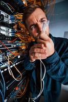 Close up view of funny man with internet wires in server room photo