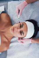 Close up view of woman that lying down in spa salon and have face cleaning procedure photo