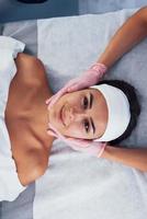 Close up view of woman that lying down in spa salon and have face cleaning procedure photo