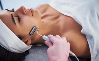 Close up view of woman that lying down in spa salon and have face cleaning procedure photo