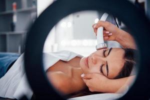 Close up view of woman that lying down in spa salon and have face cleaning procedure photo