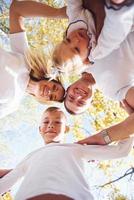 Happy family in autumn park looks down into the camera photo