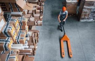 Top view of male worker in warehouse with pallet truck photo