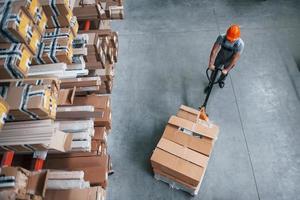 Top view of male worker in warehouse with pallet truck photo