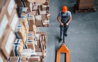 Top view of male worker in warehouse with pallet truck photo