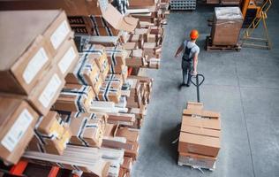 Top view of male worker in warehouse with pallet truck photo