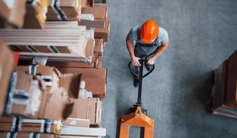 Top view of male worker in warehouse with pallet truck photo