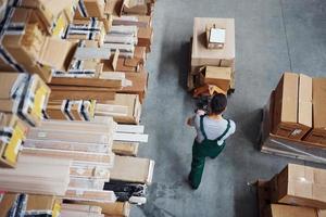 Top view of male worker in warehouse with pallet truck photo