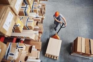 Top view of male worker in warehouse with pallet truck photo