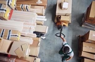 Top view of male worker in warehouse with pallet truck photo