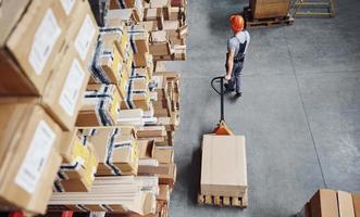 Top view of male worker in warehouse with pallet truck photo