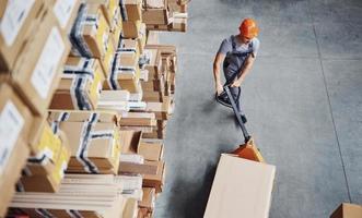 Top view of male worker in warehouse with pallet truck photo