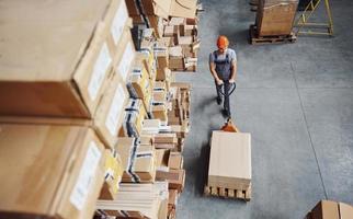 Top view of male worker in warehouse with pallet truck photo