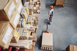 Top view of male worker in warehouse with pallet truck photo