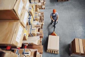 Top view of male worker in warehouse with pallet truck photo