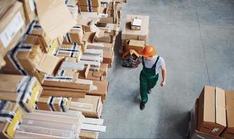 Top view of male worker in warehouse with pallet truck photo