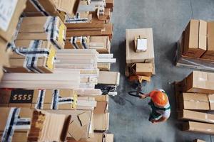 Top view of male worker in warehouse with pallet truck photo