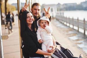 Cheerful family have a walk together with their child in the park photo