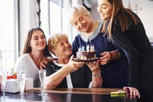 Senior woman with family and friends celebrating a birthday indoors photo