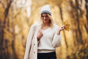 retrato de una joven morena que da un paseo por la carretera en el bosque de otoño durante el día foto