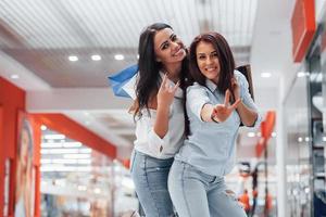 Two young women have a shopping day together in the supermarket photo