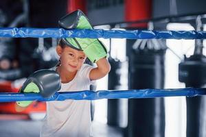 On the boxing ring. Young little girl in sportive wear is in the gym have exercise day photo