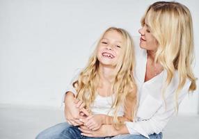 Closeness of the people. Mother with her daughter together in the studio with white background photo