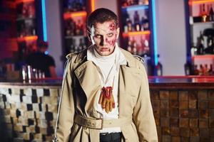 retrato de hombre que está en la fiesta temática de halloween con maquillaje y disfraz de zombi foto