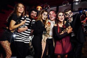 los amigos están en la fiesta temática de halloween con maquillaje y disfraces aterradores, diviértanse y posen juntos para la cámara foto