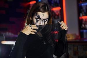 retrato de mujer que está en la fiesta temática de halloween con maquillaje y disfraces aterradores foto