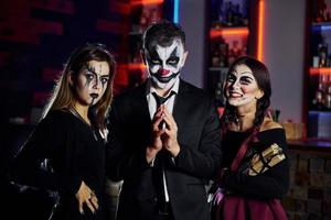 Friends is on the thematic halloween party in scary makeup and costumes have fun and posing for the camera together photo