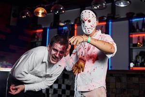 amigos están en la fiesta temática de halloween con maquillaje aterrador y disfraces de zombi foto